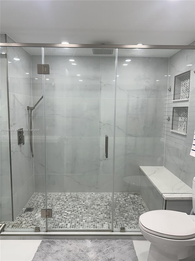 full bath featuring toilet and a stall shower
