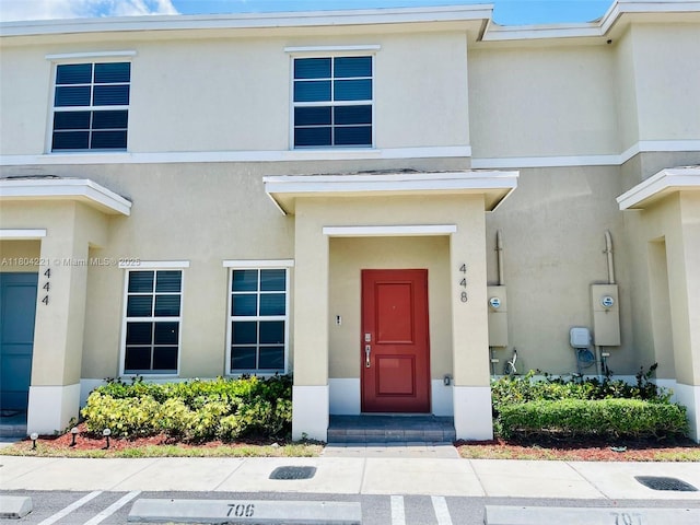 448 NE 4th St, Florida City, FL 33034 - doorway to property with stucco siding and uncovered parking