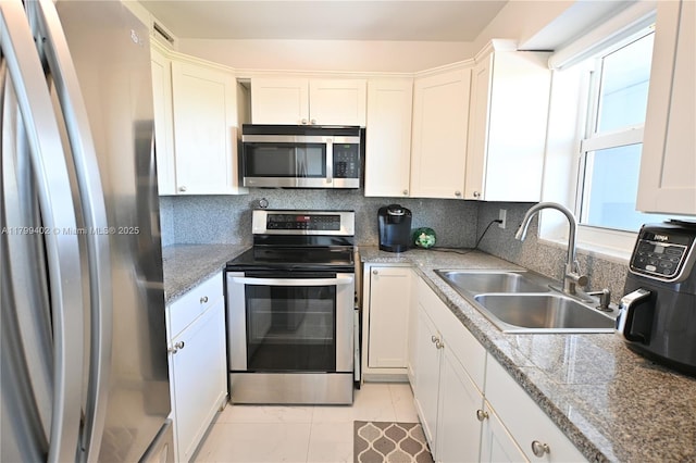 947 Lenox Ave Unit 504, Miami Beach, FL 33139 - kitchen with stainless steel appliances, a sink, white cabinets, and tasteful backsplash