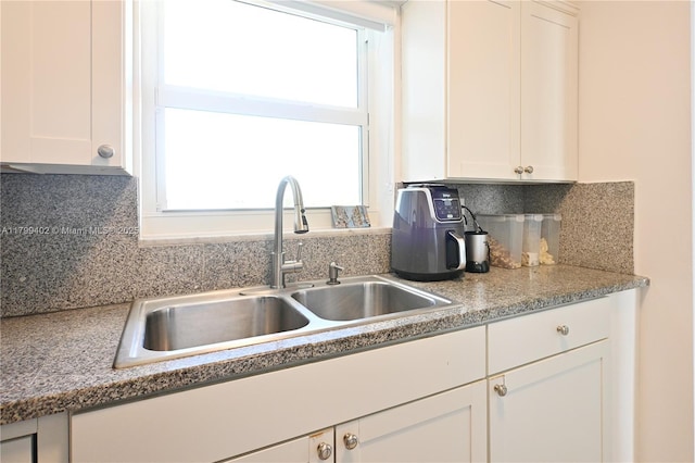 947 Lenox Ave Unit 504, Miami Beach, FL 33139 - kitchen with a sink, white cabinets, decorative backsplash, and light countertops