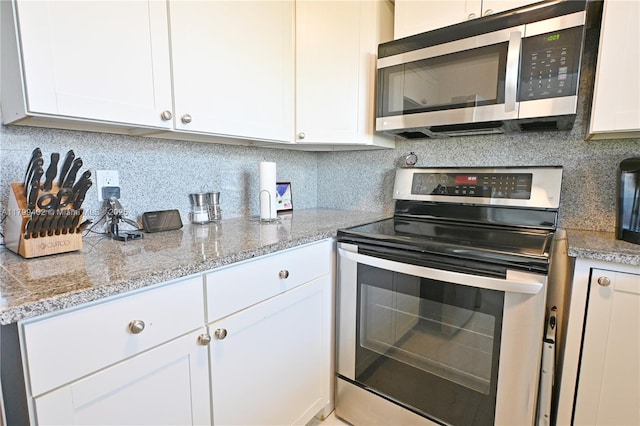 947 Lenox Ave Unit 504, Miami Beach, FL 33139 - kitchen featuring appliances with stainless steel finishes, backsplash, and white cabinets