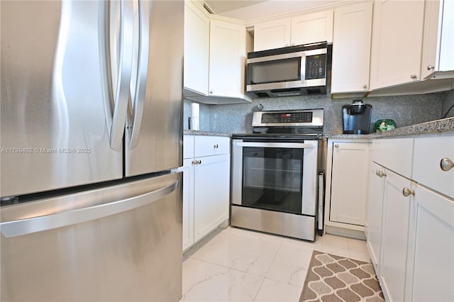 947 Lenox Ave Unit 504, Miami Beach, FL 33139 - kitchen with stainless steel appliances, light marble finish floors, white cabinets, and decorative backsplash