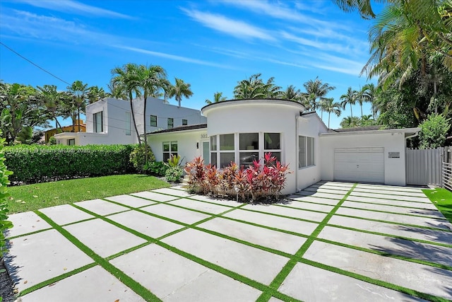 3020 Alton Rd, Miami Beach, FL 33140 - rear view of property featuring stucco siding, a garage, and concrete driveway