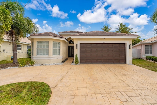 1903 SW 180th Ter, Miramar, FL 33029 - view of front of house featuring stucco siding, decorative driveway, an attached garage, and a tiled roof