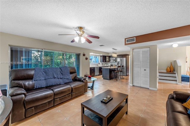 9465 SW 146th Ct, Miami, FL 33186 - living room featuring light tile patterned flooring, a ceiling fan, and a textured ceiling