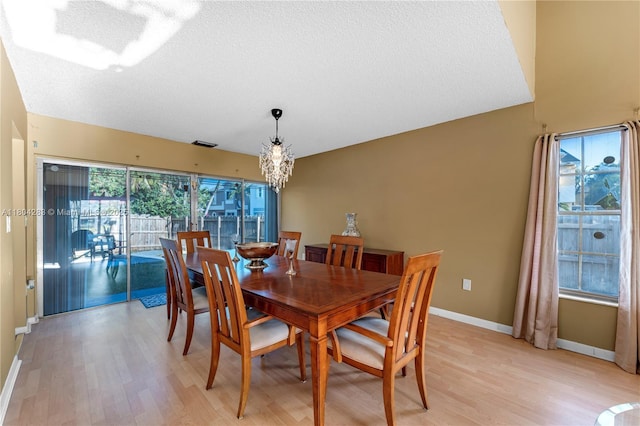 9465 SW 146th Ct, Miami, FL 33186 - dining room with light wood-style flooring, a chandelier, baseboards, and a textured ceiling