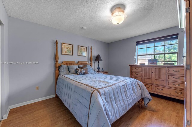 9465 SW 146th Ct, Miami, FL 33186 - bedroom featuring light wood-style flooring, a textured ceiling, and baseboards