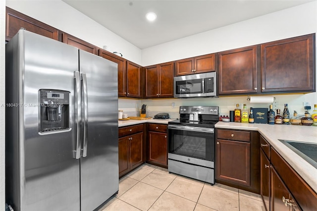 3531 W 104th Ter, Hialeah, FL 33018 - kitchen with stainless steel appliances, light countertops, light tile patterned floors, and dark brown cabinetry