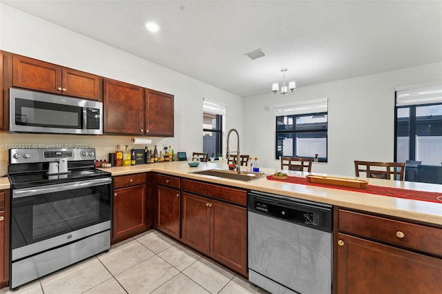 3531 W 104th Ter, Hialeah, FL 33018 - kitchen with appliances with stainless steel finishes, a sink, a chandelier, light countertops, and light tile patterned flooring