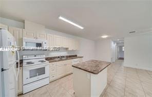 6035 SW 40th Ct, Miramar, FL 33023 - kitchen featuring white appliances, a kitchen island, and light tile patterned floors