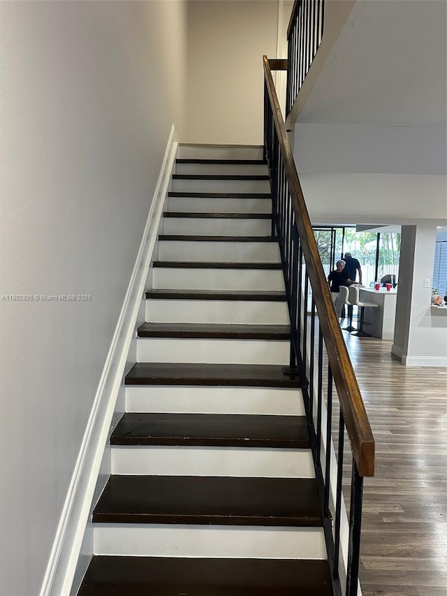 685 NE 206th Ter, Miami, FL 33179 - stairs featuring wood finished floors, a high ceiling, and baseboards