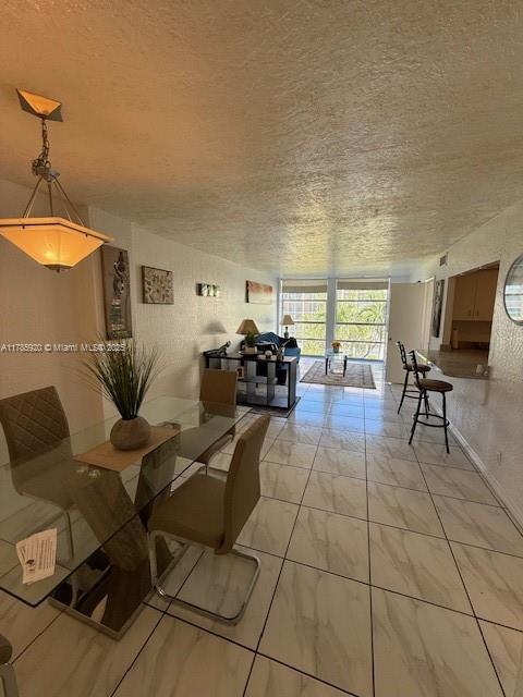 801 Three Islands Blvd Unit 302, Hallandale Beach, FL 33009 - dining room with floor to ceiling windows, a textured ceiling, and light marble finish floors