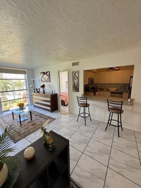 801 Three Islands Blvd Unit 302, Hallandale Beach, FL 33009 - living room featuring light marble finish floors and a textured ceiling