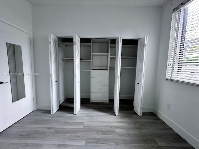 540 Brickell Key Dr Unit 302, Miami, FL 33131 - unfurnished bedroom with two closets, wood finished floors, and baseboards