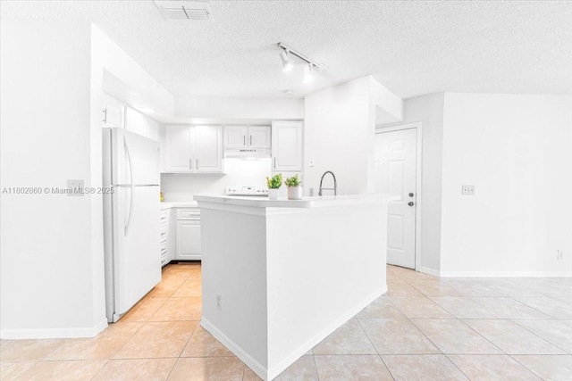 3420 N Pinewalk Dr N Unit 713, Margate, FL 33063 - kitchen featuring freestanding refrigerator, under cabinet range hood, light tile patterned floors, light countertops, and a textured ceiling