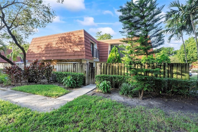 718 NW 98th Cir Unit 718, Plantation, FL 33324 - view of home's exterior featuring mansard roof and a fenced front yard