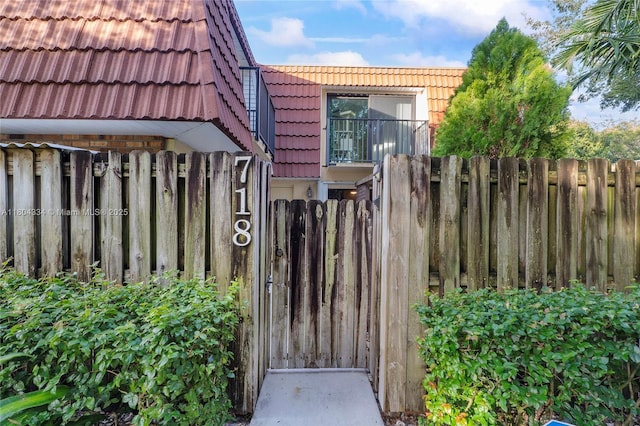 718 NW 98th Cir Unit 718, Plantation, FL 33324 - entrance to property with a tiled roof, fence, and mansard roof