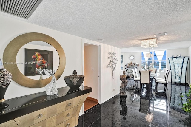 301 174th St Unit 1503, Sunny Isles Beach, FL 33160 - dining space featuring granite floors, a textured ceiling, a chandelier, and baseboards