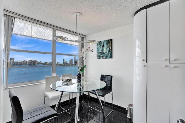 301 174th St Unit 1503, Sunny Isles Beach, FL 33160 - dining room with a view of skyline, a textured ceiling, a water view, and baseboards