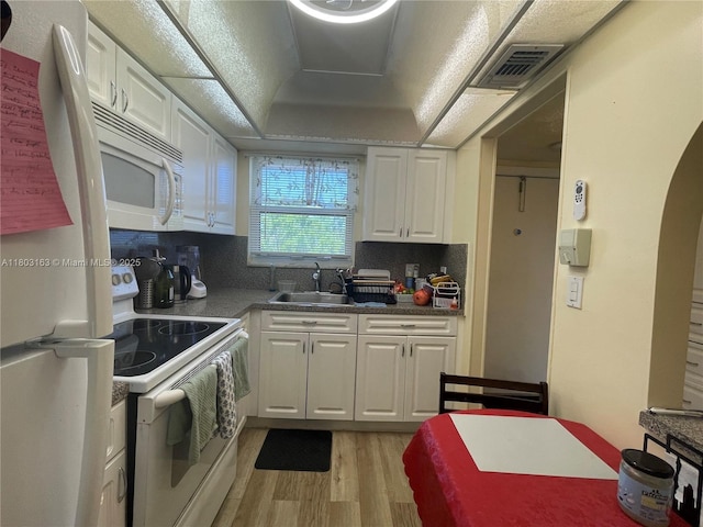 2911 N Pine Island Rd Unit 311, Sunrise, FL 33322 - kitchen with white appliances, a sink, light wood-type flooring, white cabinets, and tasteful backsplash