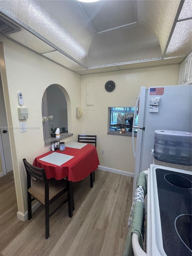 2911 N Pine Island Rd Unit 311, Sunrise, FL 33322 - dining room with light wood-style floors, arched walkways, baseboards, and a raised ceiling