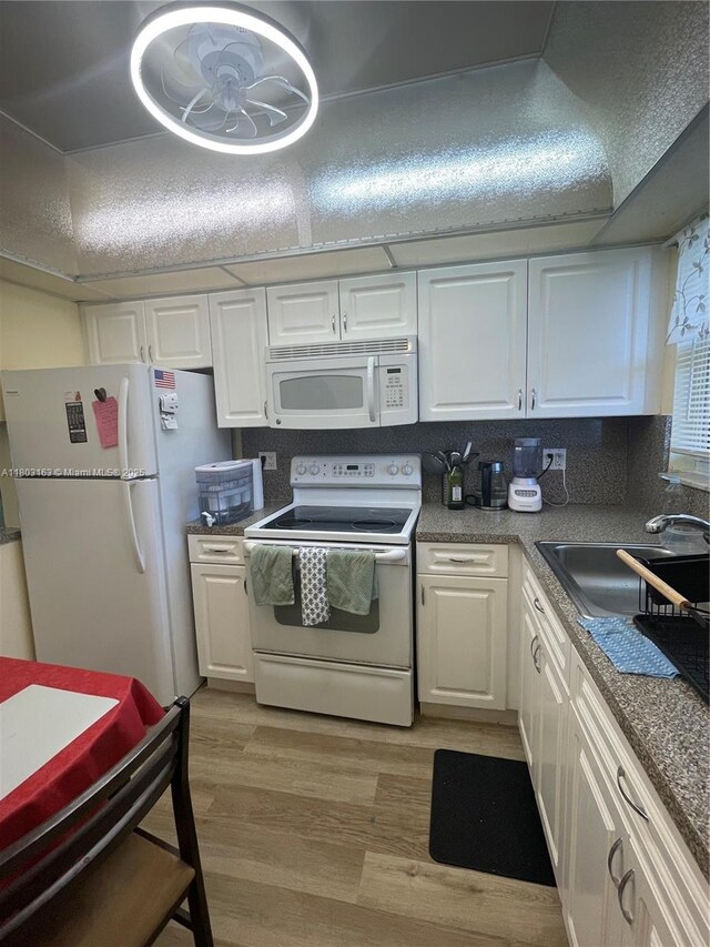 2911 N Pine Island Rd Unit 311, Sunrise, FL 33322 - kitchen featuring white appliances, a sink, white cabinets, and light wood-style floors