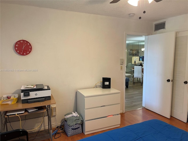 2911 N Pine Island Rd Unit 311, Sunrise, FL 33322 - bedroom with wood finished floors, a closet, a ceiling fan, and a textured ceiling