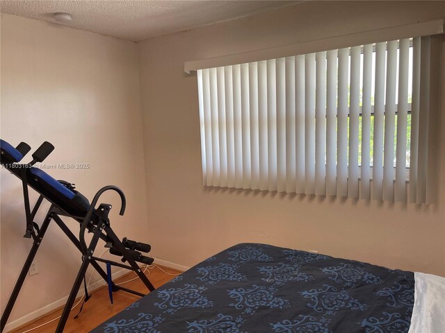 2911 N Pine Island Rd Unit 311, Sunrise, FL 33322 - bedroom featuring baseboards, wood finished floors, and multiple windows