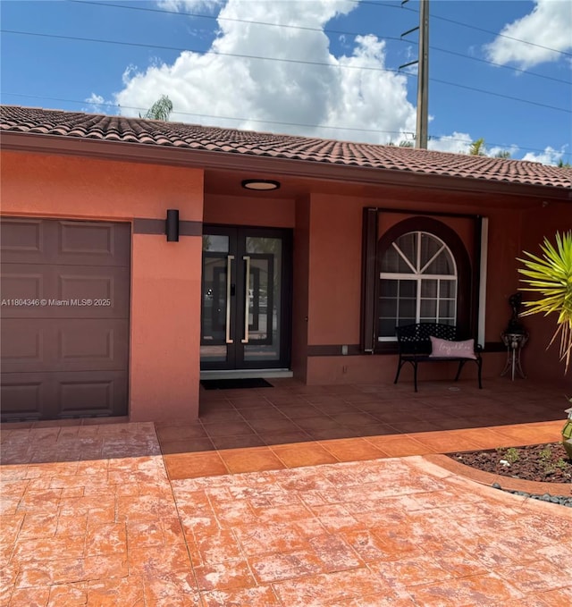 14620 SW 151st Ter, Miami, FL 33186 - view of exterior entry featuring french doors, stucco siding, and a tile roof
