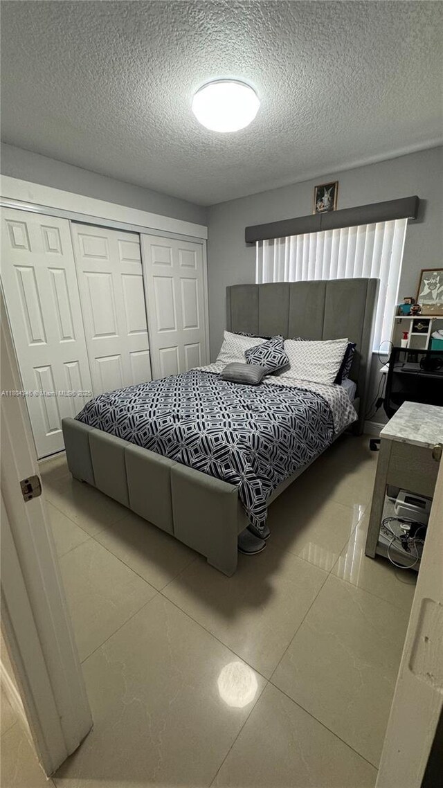 14620 SW 151st Ter, Miami, FL 33186 - tiled bedroom featuring a closet and a textured ceiling