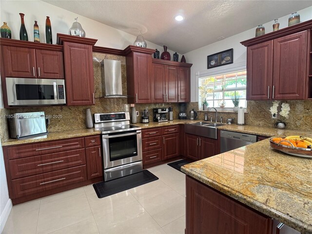 14620 SW 151st Ter, Miami, FL 33186 - kitchen with appliances with stainless steel finishes, wall chimney exhaust hood, a sink, reddish brown cabinets, and tasteful backsplash