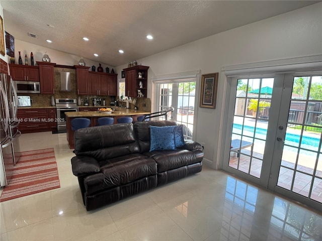 14620 SW 151st Ter, Miami, FL 33186 - living area featuring lofted ceiling, plenty of natural light, recessed lighting, light tile patterned floors, and a textured ceiling