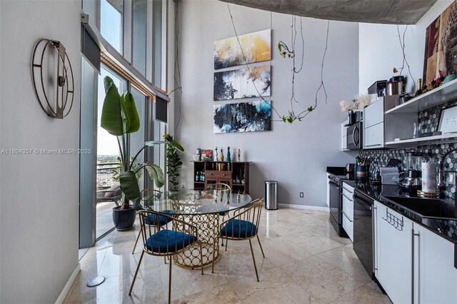 690 SW 1st Ct Unit Phi26, Miami, FL 33130 - kitchen with black appliances, light marble finish floors, dark countertops, open shelves, and a high ceiling