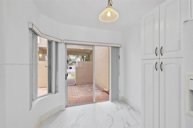 doorway featuring baseboards and light marble finish floors