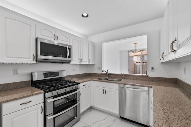 kitchen with stainless steel appliances, a sink, white cabinets, recessed lighting, and light marble finish floors