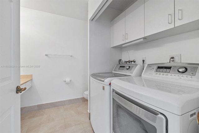 clothes washing area with washing machine and clothes dryer and cabinet space