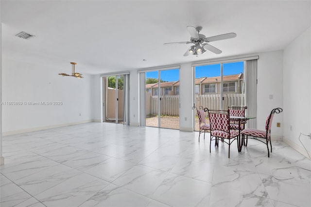 dining space featuring marble look tile flooring, baseboards, and a ceiling fan
