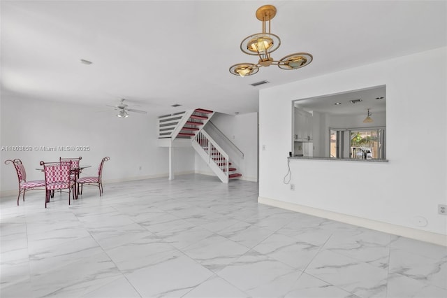 dining room featuring stairs, marble look tiles, a ceiling fan, and a chandelier