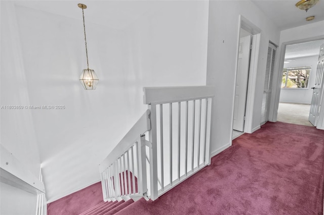 hallway featuring carpet flooring and an upstairs landing