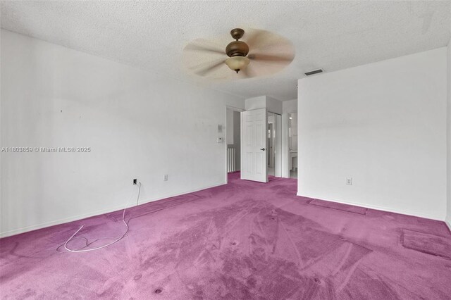 carpeted spare room featuring ceiling fan and a textured ceiling