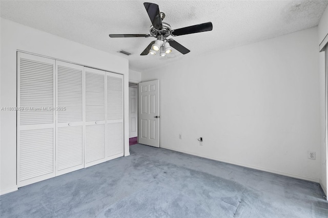 unfurnished bedroom with carpet, a closet, a textured ceiling, and ceiling fan