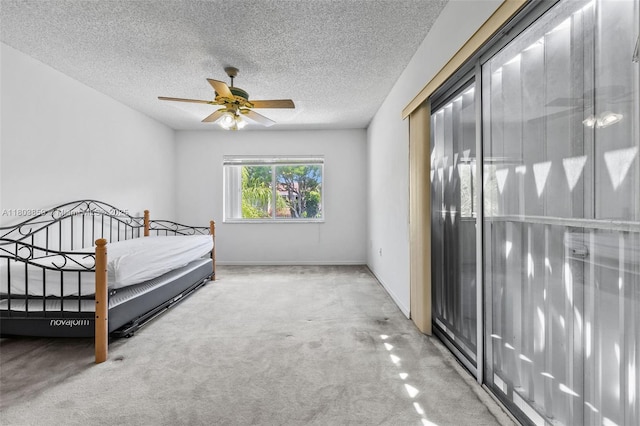 carpeted bedroom featuring a textured ceiling, baseboards, and ceiling fan