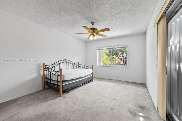 carpeted bedroom featuring a textured ceiling, baseboards, and ceiling fan