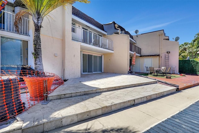 2807 NE 164th St Unit 2, North Miami Beach, FL 33160 - back of house featuring stucco siding, a patio area, a balcony, and outdoor dining space