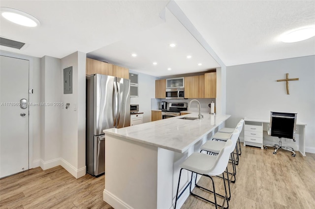 800 SE 20th Ave Unit 303, Deerfield Beach, FL 33441 - kitchen with appliances with stainless steel finishes, a peninsula, light wood-type flooring, a kitchen breakfast bar, and recessed lighting