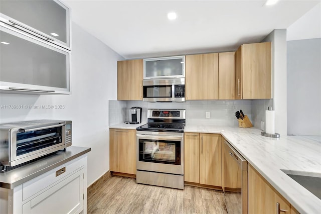 800 SE 20th Ave Unit 303, Deerfield Beach, FL 33441 - kitchen with appliances with stainless steel finishes, light wood-style flooring, decorative backsplash, glass insert cabinets, and recessed lighting
