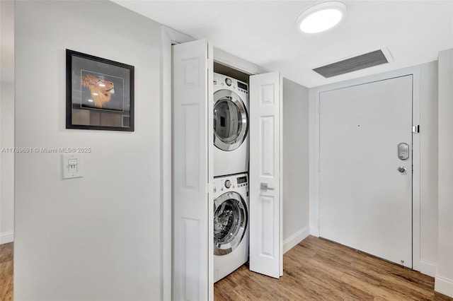 800 SE 20th Ave Unit 303, Deerfield Beach, FL 33441 - laundry room with stacked washer / dryer, light wood-style floors, and baseboards