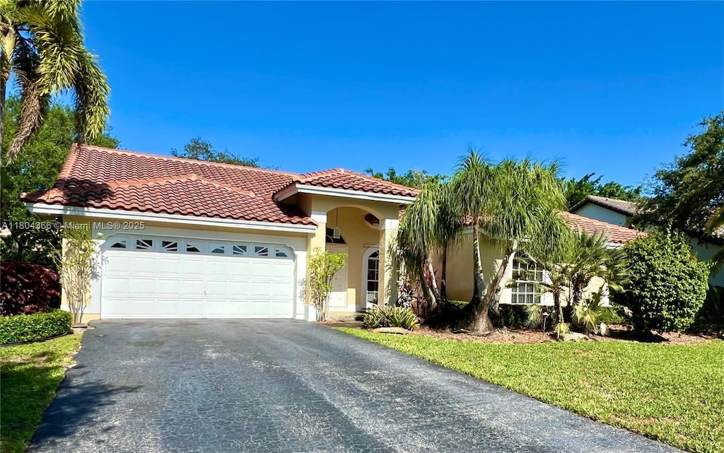 5407 NW 107th Ave, Coral Springs, FL 33076 - mediterranean / spanish-style house featuring asphalt driveway, stucco siding, a tile roof, and an attached garage