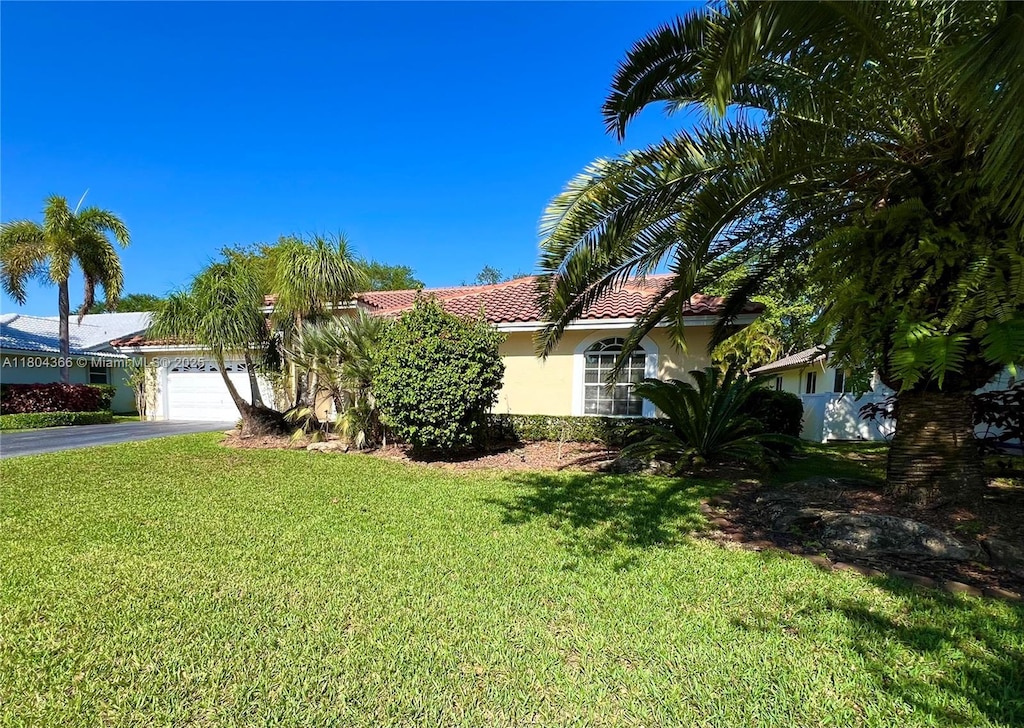 5407 NW 107th Ave, Coral Springs, FL 33076 - view of front of property featuring driveway, stucco siding, a front lawn, and an attached garage