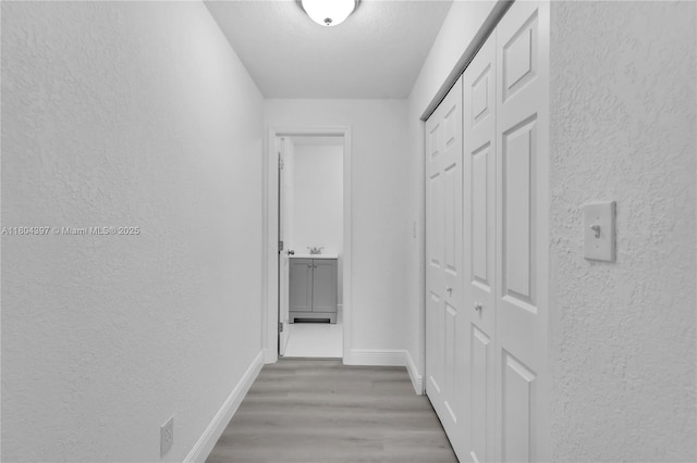 8330 NW 35th Pl, Miami, FL 33147 - hallway featuring a textured wall, baseboards, and wood finished floors